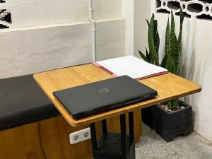 a laptop computer sitting on a wooden table at Hotel O Kost Maharaja Near Maros in Makassar +36 photos