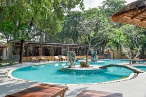 a pool with a fountain in the middle of a courtyard at Villa Cha Cha Chaolao Beach Resort in Chao Lao Beach