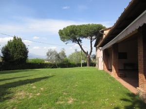 a yard next to a house with a green lawn at Casal Bengodi in Poggio a Caiano