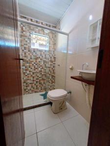 a bathroom with a shower and a toilet and a sink at Casa com 3 suítes em Cabo Frio com piscina há poucos passos do Mar! in Cabo Frio