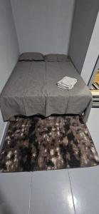 ein Bett in einem kleinen Zimmer mit einem Teppich in der Unterkunft Só pra relaxar! in Manaus