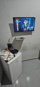 a flat screen tv on a wall with a table at Só pra relaxar! in Manaus