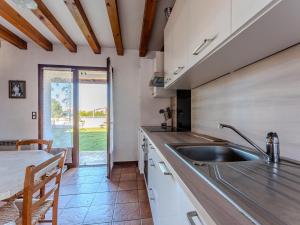 a kitchen with a sink and a counter with a table at Maison chaleureuse avec terrasse et jardin, proche plage et centre-ville - 6 pers, Biscarrosse - FR-1-521-34 in Biscarrosse-Plage +4 photos