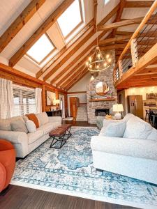 a living room with two couches and a stone fireplace at Cabin Sweet Cabin in Burlington
