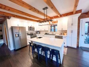 a kitchen with white cabinets and a island with bar stools at Cabin Sweet Cabin in Burlington