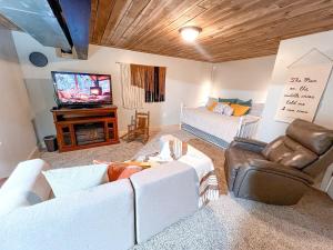 a living room with white couches and a television at Cabin Sweet Cabin in Burlington