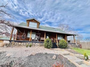 a large wooden house with a green roof at Cabin Sweet Cabin in Burlington