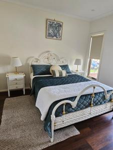 ein Schlafzimmer mit einem großen Bett mit blau-weißer Bettwäsche in der Unterkunft Beautiful Abode in Tarneit in Tarneit