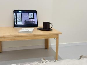 a computer monitor sitting on top of a wooden table at Ribini house in Seoul