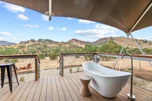 a bath tub on a deck with a view of the desert at Jara II in Berremangra +14 photos