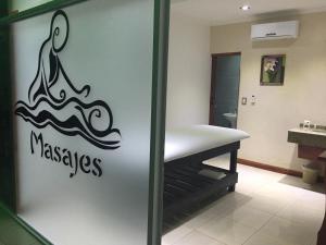 a bathroom with a door with a sign that reads massage at Hotel Carmen in Puerto Iguazú
