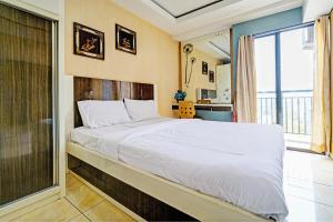 a large bed in a room with a large window at OYO Life 93170 Apartement Gateway Cicadas By Mr Pro in Bandung