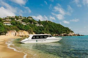 a boat in the water on a beach at Banyan Tree Samui in Lamai