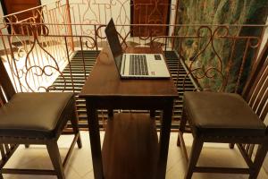 a laptop computer sitting on a table on a balcony at SPOT ON 93189 Rumah Berkah Syariah in Blitar
