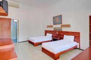 Postel nebo postele na pokoji v ubytování Capital O 93236 Hotel Hapel Negara