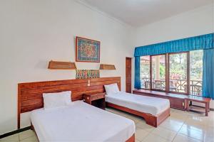 Postel nebo postele na pokoji v ubytování Capital O 93236 Hotel Hapel Negara