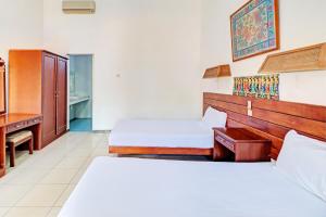 Postel nebo postele na pokoji v ubytování Capital O 93236 Hotel Hapel Negara