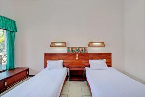 Postel nebo postele na pokoji v ubytování Capital O 93236 Hotel Hapel Negara