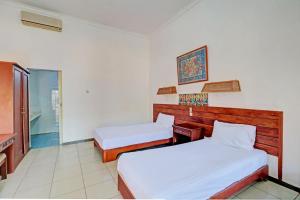 Postel nebo postele na pokoji v ubytování Capital O 93236 Hotel Hapel Negara
