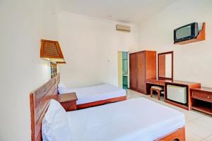 Postel nebo postele na pokoji v ubytování Capital O 93236 Hotel Hapel Negara