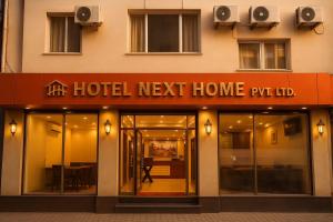 un hotel accanto casa puteri insegna sul lato anteriore di un edificio di Hotel next home a Kathmandu