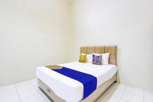 Postel nebo postele na pokoji v ubytování SPOT ON 93245 Guest House Mulia Dua Syariah