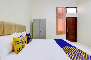 Postel nebo postele na pokoji v ubytování SPOT ON 93245 Guest House Mulia Dua Syariah