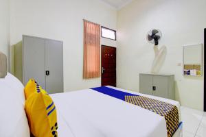 Postel nebo postele na pokoji v ubytování SPOT ON 93245 Guest House Mulia Dua Syariah