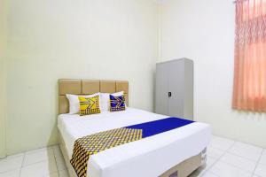 Postel nebo postele na pokoji v ubytování SPOT ON 93245 Guest House Mulia Dua Syariah