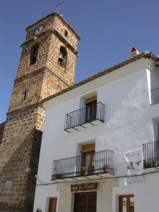 un edificio con una torre dell'orologio sopra di Suite La Plaza a Letur