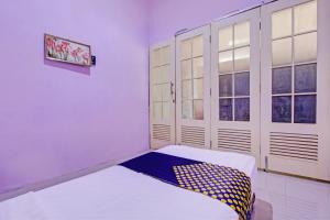 a room with a bed and two windows at Hotel O Sengon Kostel Syariah in Jepara