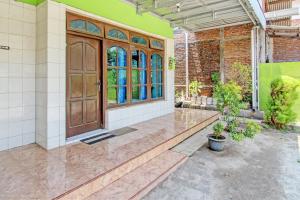 an entry to a house with a wooden door at Hotel O Sengon Kostel Syariah in Jepara +16 photos