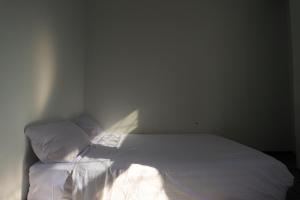 BagamにあるHotel O Homestay OrangeNearNagoya Hill Shopping Mallの白いシーツと枕が備わったベッドのある寝室 +30枚の写真