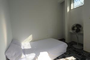 BagamにあるHotel O Homestay OrangeNearNagoya Hill Shopping Mallのベッドルーム(白いベッド1台、ファン付)