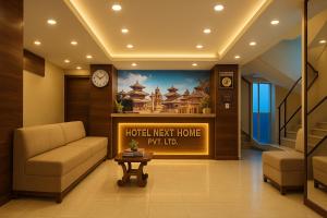 una hall con un hotel accanto, il cui nome principale è riportato sul muro di Hotel next home a Kathmandu