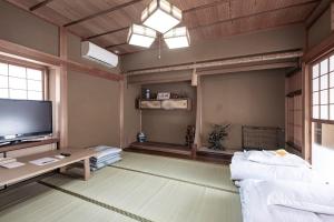 a living room with a couch and a tv at Dog-friendly private lodging HURU in Takashima