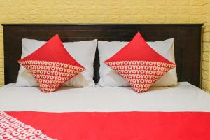 two red pillows sitting on top of a bed at OYO 93333 Rama Home Stay in Jayapura