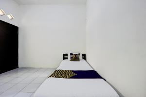a white room with a bed in a room at OYO Life 93398 Sudimoro Guest House Syariah in Blimbing
