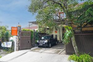 a car parked in the driveway of a house at Hotel O Sukamulya Homestay in Bandung