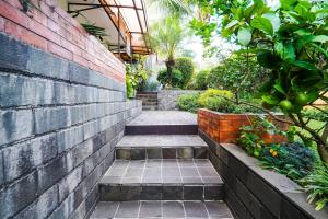 a garden with a brick wall and some plants at Hotel O Sukamulya Homestay in Bandung +25 photos