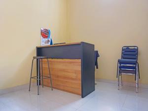 een bureau en 2 stoelen in een kamer bij Hotel O Pondok Kula Rumbih Syariah in Sungairasau