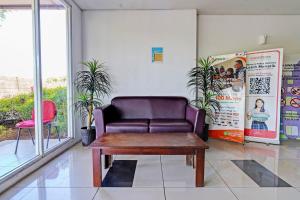 a waiting room with a leather couch and a table at Hotel O Apartement Grand Sentraland By Rai Property in Jaken 1