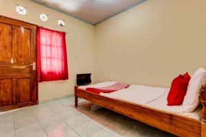 a bedroom with a bed and a red window at Hotel O Pondok Wisata Sekar KemuningNearWonogondang Camp ( Bumi Perkemahan Wonogondang ) in Yogyakarta