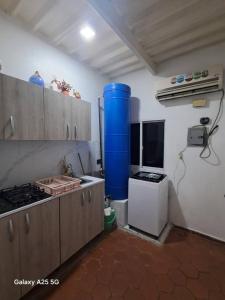 eine Küche mit Herd und blauem Fass in der Unterkunft Apto Comodo cerca de Centro de Puerto La Cruz in Puerto La Cruz