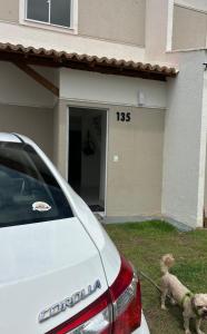 a dog on a leash standing in front of a house at Casa em Parnaíba lazer e praia in Parnaíba +12 photos