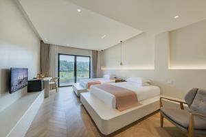 a hotel room with two beds and a tv at 莫干山缦田生态度假酒店 in Deqing