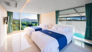 two beds in a room with a large window at Opus11 Poolvilla in Gyeongju +70 photos