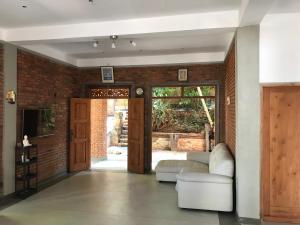AmpitiyaにあるKandy Brick Bungalowの白いソファとレンガの壁が備わるリビングルーム