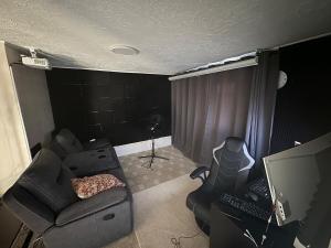 a living room with a couch and a desk with a computer at Full 2 Bedroom Cozy Stay Near Niagara Falls in Welland