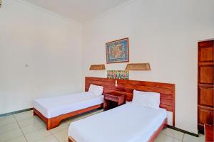 Postel nebo postele na pokoji v ubytování Capital O 93236 Hotel Hapel Negara